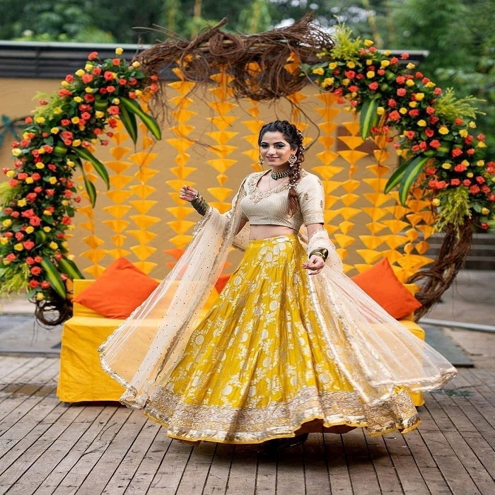 येलो और गोल्डन लुक का यह यूनिक लहंगा भी आप मेहंदी फंक्शन में पहन सकते हैं।