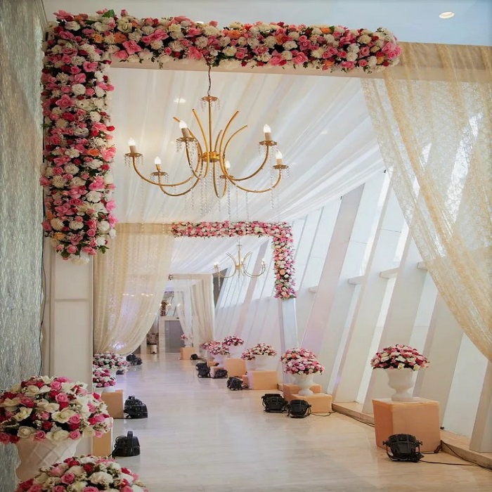 व्हाइट और पिंक फूलों के साथ सिंपल और अट्रेक्टिव लुक से आप एंट्रेस सजा सकते हैं।